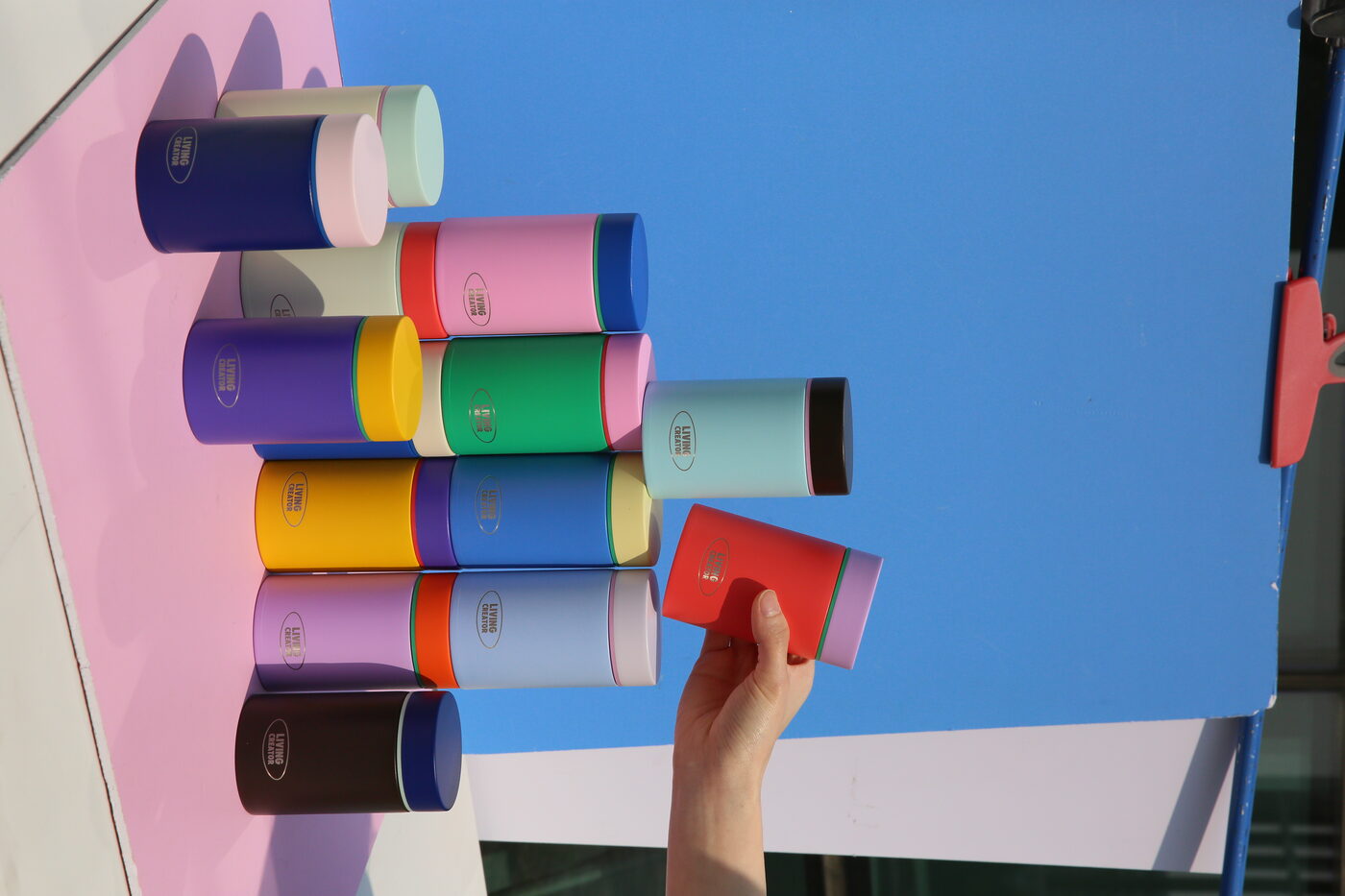 A hand setting a red lid onto a wall of MyTum bodies